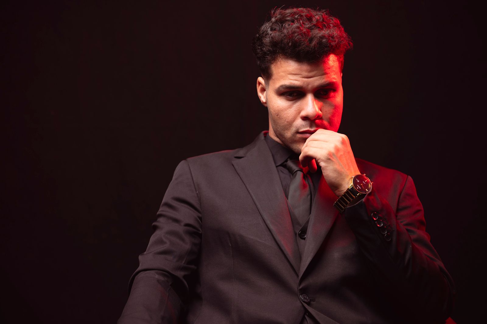 Real Pexels portrait of a thoughtful executive in black with a red light accent