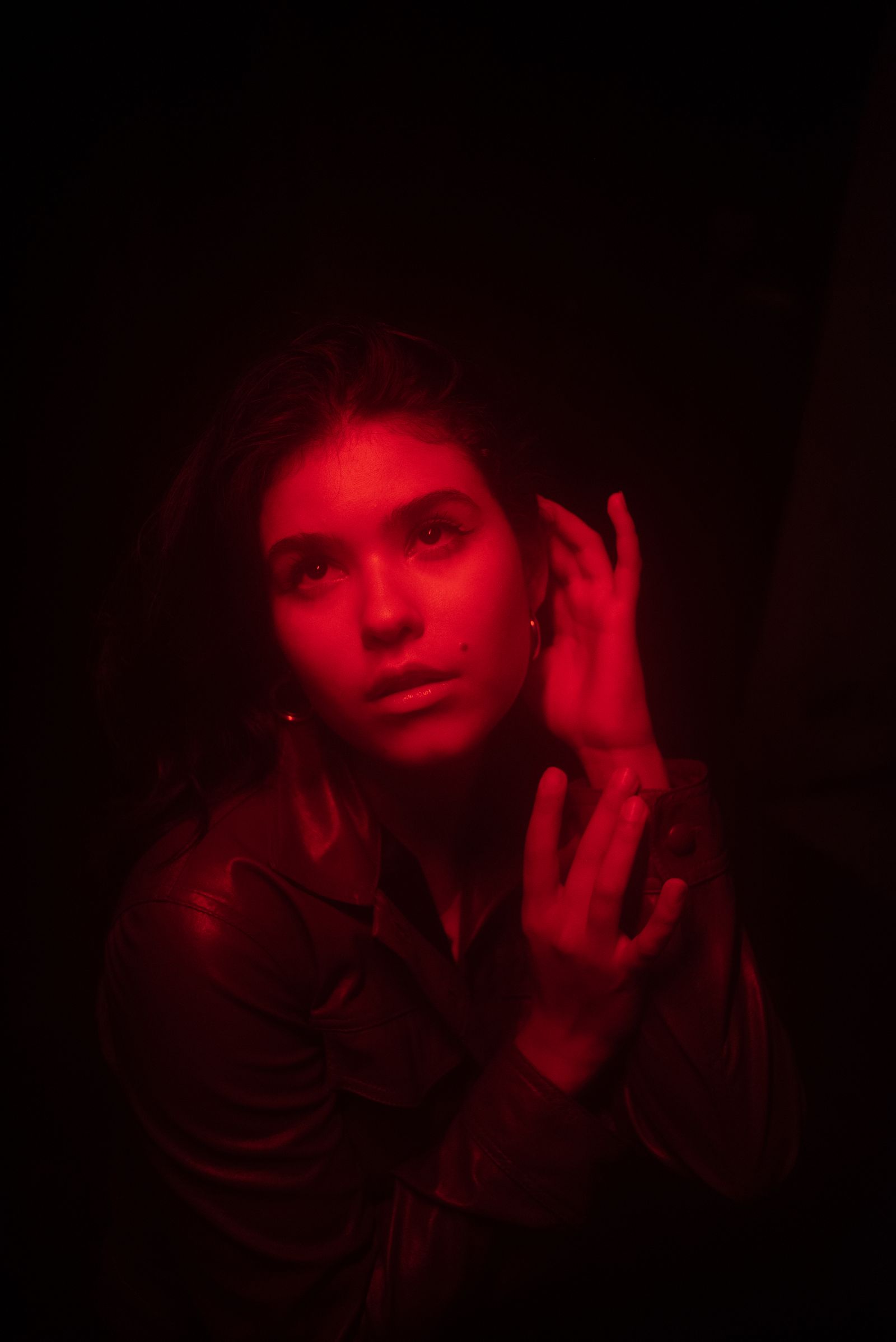 Real Pexels portrait of a woman against a black background with deep red light